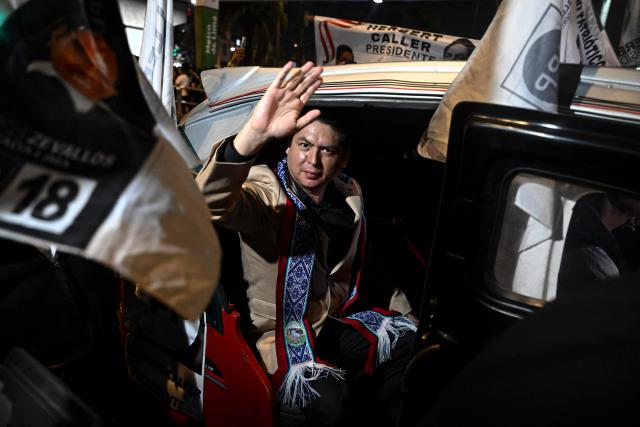 Peru's presidential candidate Herbert Caller, for the Patriotic Party of Peru, waves from a "tuktuk" upon his arrival for the second round of debates on education and employment at the Lima Convention Center in Lima on March 31, 2026. Peru will hold presidential elections on April 12. (Photo by ERNESTO BENAVIDES / AFP)
