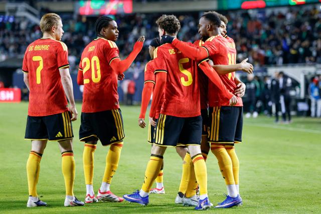 Belgium's forward #14 Dodi Lukebakio (R) is congratulated by teammates after scoring a goal during a friendly football match between Mexico and Belgium at Soldier Field in Chicago, Illinois, on March 31, 2026. (Photo by KAMIL KRZACZYNSKI / AFP)
