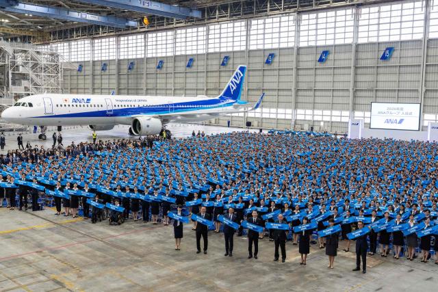 New employees of All Nippon Airways (ANA) Group attend an annual entrance ceremony at an aircraft hangar of Tokyo's Haneda Airport on April 1, 2026, the first day of the new fiscal year. (Photo by Kazuhiro NOGI / AFP)
