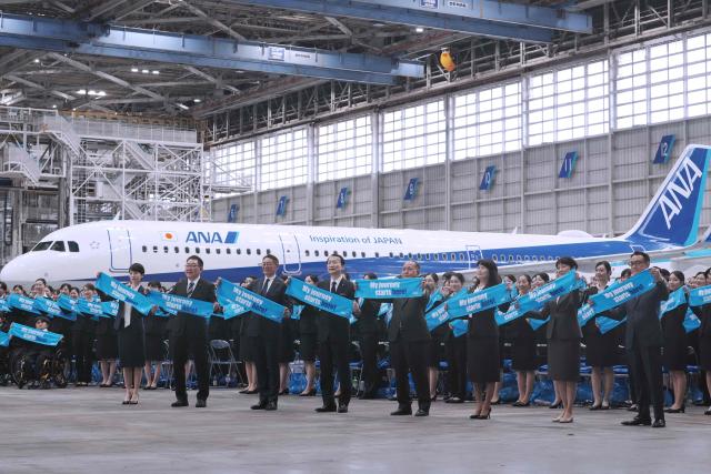 All Nippon Airways executives (front row) and new employees of ANA Group attend an annual entrance ceremony at an aircraft hangar of Tokyo's Haneda Airport on April 1, 2026, the first day of the new fiscal year. (Photo by Kazuhiro NOGI / AFP)