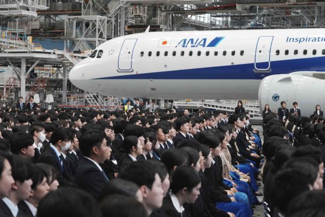 New employees of All Nippon Airways (ANA) Group attend an annual entrance ceremony at an aircraft hangar of Tokyo's Haneda Airport on April 1, 2026, the first day of the new fiscal year. (Photo by Kazuhiro NOGI / AFP)