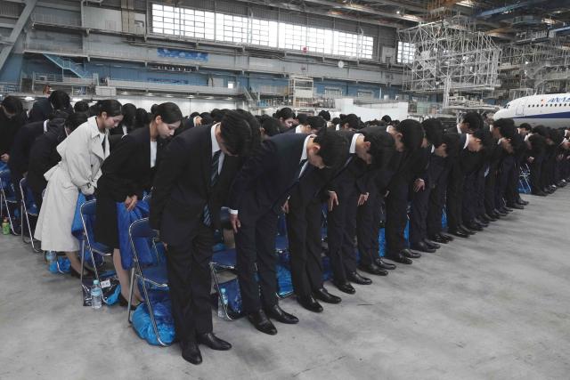 New employees of All Nippon Airways (ANA) Group attend an annual entrance ceremony at an aircraft hangar of Tokyo's Haneda Airport on April 1, 2026, the first day of the new fiscal year. (Photo by Kazuhiro NOGI / AFP)