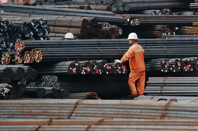 Workers handle steel rods at a steel market in Hangzhou, in eastern China's Zhejiang province, on March 31, 2026. (Photo by -STR / CN-STR / AFP) / China OUT