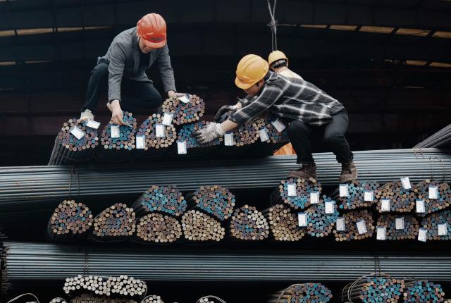 Workers handle steel rods at a steel market in Hangzhou, in eastern China's Zhejiang province, on March 31, 2026. (Photo by -STR / CN-STR / AFP) / China OUT