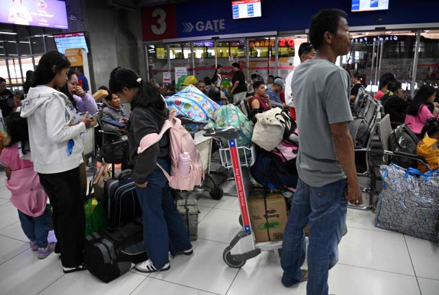 Passengers wait for their departure at a bus terminal in Manila on April 1, 2026, as Filipinos trooped to bus terminals, airport, and sea ports to head home for the annual Easter holidays. (Photo by Ted ALJIBE / AFP)