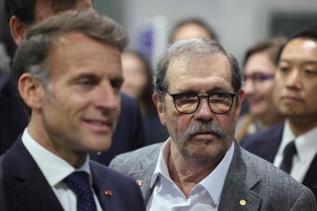 French President Emmanuel Macron (L) and French physicist Alain Aspect (R), who was awarded the 2022 Nobel Prize in Physics, visit the LIMMS facilities, in partnership with French CNRS International Research Laboratory, in Tokyo on April 1, 2026. (Photo by Ludovic MARIN / POOL / AFP)