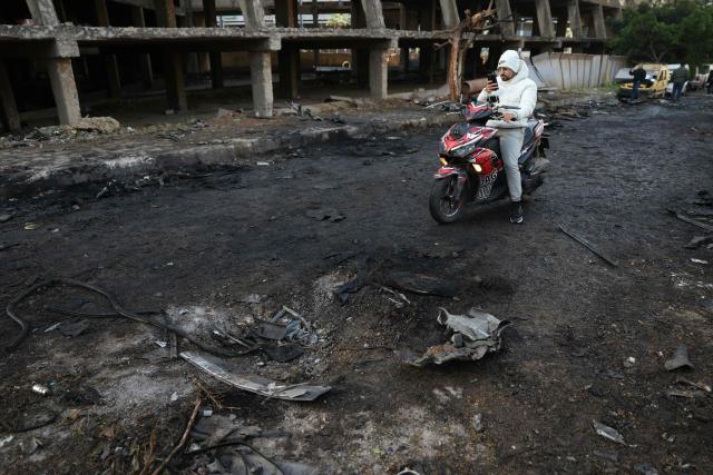 A man on a scooter takes pictures of the damage at the site of an Israeli strike in Beirut on April 1, 2026. Lebanon was drawn into the Middle East war on March 2 when Tehran-backed militant group Hezbollah launched attacks on Israel to avenge the killing of the Iranian leader. Israel has responded with broad strikes across Lebanon and a ground offensive. (Photo by Anwar AMRO / AFP)