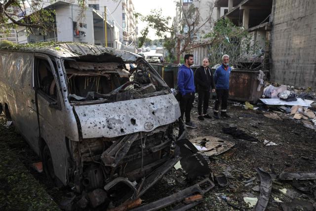 Men look at the damage next to the wreckage of a vehicle at the site of an Israeli strike in Beirut on April 1, 2026. Lebanon was drawn into the Middle East war on March 2 when Tehran-backed militant group Hezbollah launched attacks on Israel to avenge the killing of the Iranian leader. Israel has responded with broad strikes across Lebanon and a ground offensive. (Photo by Anwar AMRO / AFP)