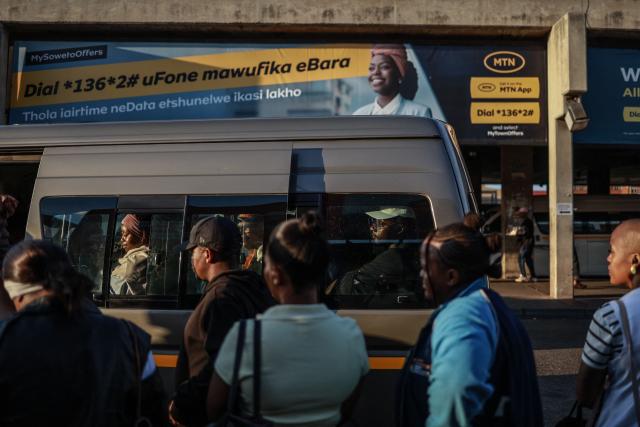 Commuters queue to board a minibus taxi at Bara Taxi rank in Soweto on April 1, 2026, a day after South Africa lowered its fuel tax for a month to offset a global oil price surge driven by the Iran war, even as pump prices rose in one of the steepest increases on record. (Photo by Phill Magakoe / AFP)