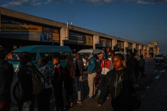Commuters queue to board a minibus taxi at Bara Taxi rank in Soweto on April 1, 2026, a day after South Africa lowered its fuel tax for a month to offset a global oil price surge driven by the Iran war, even as pump prices rose in one of the steepest increases on record. (Photo by Phill Magakoe / AFP)