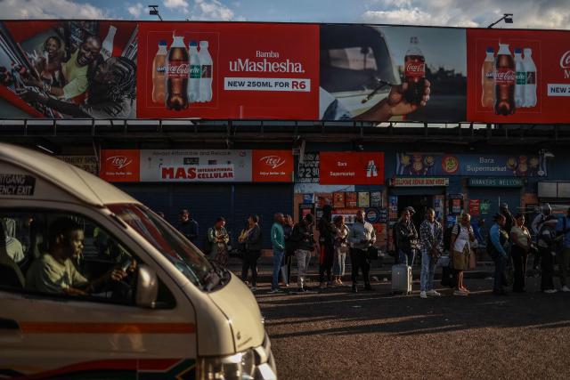 Commuters queue to board a minibus taxi at Bara Taxi rank in Soweto on April 1, 2026, a day after South Africa lowered its fuel tax for a month to offset a global oil price surge driven by the Iran war, even as pump prices rose in one of the steepest increases on record. (Photo by Phill Magakoe / AFP)