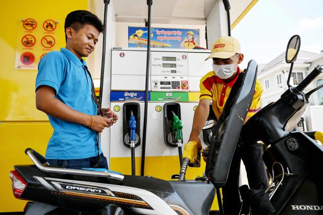 An employee pumps gasoline into the motorbike of a customer at a fuel station in Phnom Penh on April 1, 2026. Cambodia's diesel price on April 1 reached double its level at the start of the Middle East war after the latest government increase, official figures showed, raising concerns among farmers ahead of ploughing season. (Photo by TANG CHHIN Sothy / AFP)