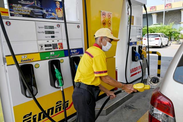 An employee pumps gasoline into the vehicle of a customer at a fuel station in Phnom Penh on April 1, 2026. Cambodia's diesel price on April 1 reached double its level at the start of the Middle East war after the latest government increase, official figures showed, raising concerns among farmers ahead of ploughing season. (Photo by TANG CHHIN Sothy / AFP)