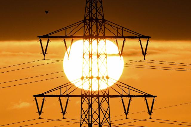 The sun rises behind a pylon and power lines in Frankfurt am Main, western Germany, on April 1, 2026. (Photo by Kirill KUDRYAVTSEV / AFP)