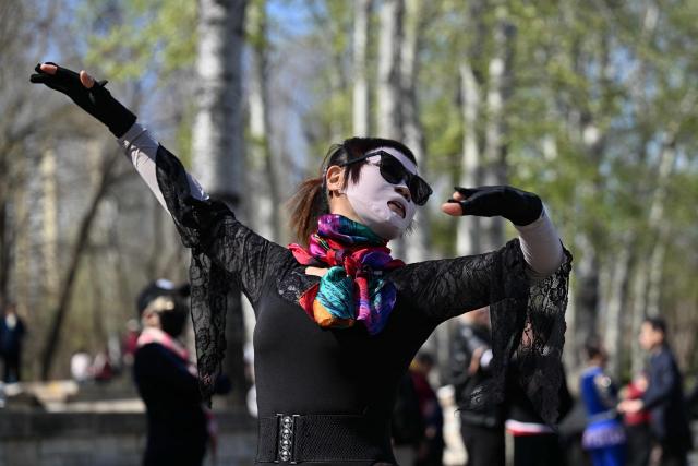 People practice dancing at a park in Beijing on April 1, 2026. (Photo by ADEK BERRY / AFP)
