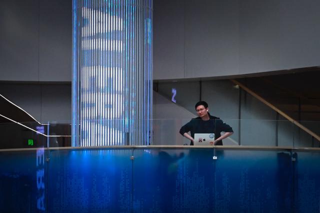An employee looks on during a tour at the Alibaba office in Beijing on April 1, 2026. (Photo by WANG Zhao / AFP)