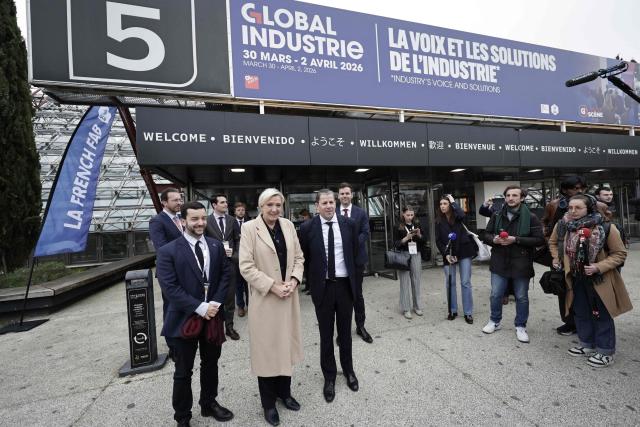 Far-right Rassemblement National (RN) parliamentary group president Marine Le Pen (C) and Rassemblement National's MP Jean-Philippe Tanguy (L) pose as they arrive to visit the Global Industrie trade show at the Paris Nord Villepinte exhibition centre in Villepinte,  northeast of Paris, on April 1, 2026. (Photo by STEPHANE DE SAKUTIN / AFP)