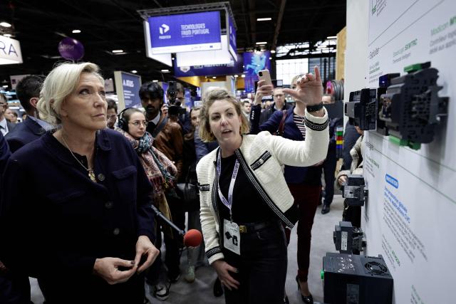 Far-right Rassemblement National (RN) parliamentary group president Marine Le Pen (L) is given a tour as she visits the Global Industrie trade show at the Paris Nord Villepinte exhibition centre in Villepinte,  northeast of Paris, on April 1, 2026. (Photo by STEPHANE DE SAKUTIN / AFP)