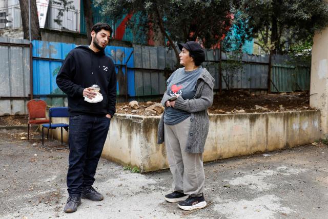 Raz Malka and Ayala Amar stand near a protected area during an interview with AFP in the northern Israeli town of Kiryat Shmona near the border with Lebanon on March 30, 2026. Lives paced by sirens and confined within four walls. The city is empty, deserted by its young people. In Kiryat Shmona, on the frontline of the war between Israel and Lebanon's Hezbollah, those who have stayed can't take it anymore and feel "neglected" by the government. (Photo by Jalaa MAREY / AFP)