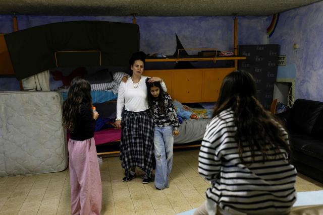 Olga speaks with her children inside a shelter in the northern Israeli town of Kiryat Shmona near the border with Lebanon on March 30, 2026. Lives paced by sirens and confined within four walls. The city is empty, deserted by its young people. In Kiryat Shmona, on the frontline of the war between Israel and Lebanon's Hezbollah, those who have stayed can't take it anymore and feel "neglected" by the government. (Photo by Jalaa MAREY / AFP)