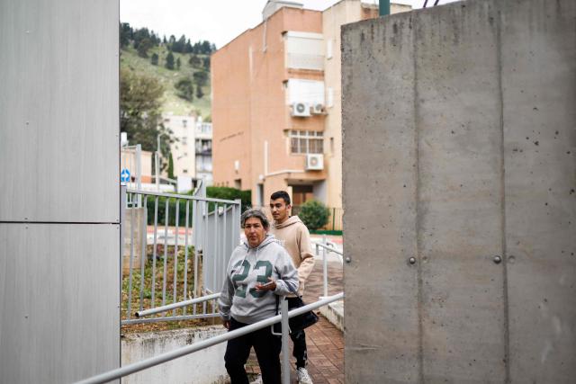 Residents walk into a clinic run by Clalit Health Services in the northern Israeli town of Kiryat Shmona near the border with Lebanon on March 30, 2026. Lives paced by sirens and confined within four walls. The city is empty, deserted by its young people. In Kiryat Shmona, on the frontline of the war between Israel and Lebanon's Hezbollah, those who have stayed can't take it anymore and feel "neglected" by the government. (Photo by Jalaa MAREY / AFP)