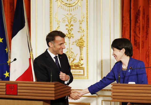 Japan's Prime Minister Sanae Takaichi and French President Emmanuel Macron shake hands during a press conference at Akasaka Palace in Tokyo on April 1, 2026. (Photo by Franck ROBICHON / POOL / AFP)