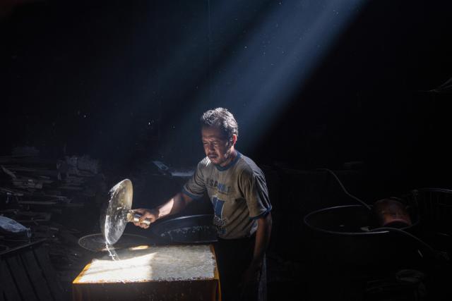A worker cooks soybean paste to produce traditional tofu in Bandung, West Java, April 1, 2026. (Photo by Timur Matahari / AFP)