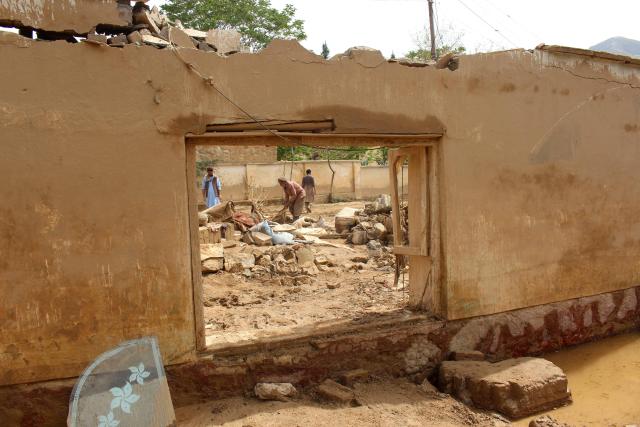 Afghan men search for their household goods inside damaged homes after flash floods on the outskirts of Pul-e Khumri in Baghlan Province on April 1, 2026. Rain sweeping across Afghanistan has caused floods and landslides in multiple provinces. Among the poorest countries in the world after decades of war, Afghanistan is particularly exposed to the effects of climate change, which scientists say is spurring extreme weather. (Photo by AFP)