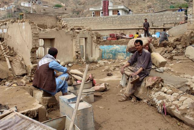 Afghan men sit at damaged houses after flash floods on the outskirts of Pul-e Khumri in Baghlan Province on April 1, 2026. Rain sweeping across Afghanistan has caused floods and landslides in multiple provinces. Among the poorest countries in the world after decades of war, Afghanistan is particularly exposed to the effects of climate change, which scientists say is spurring extreme weather. (Photo by AFP)