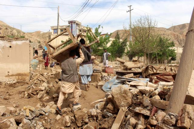 Afghan men carry their household goods from damaged homes after flash floods on the outskirts of Pul-e Khumri in Baghlan Province on April 1, 2026. Rain sweeping across Afghanistan has caused floods and landslides in multiple provinces. Among the poorest countries in the world after decades of war, Afghanistan is particularly exposed to the effects of climate change, which scientists say is spurring extreme weather. (Photo by AFP)