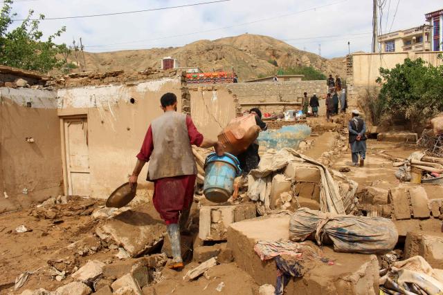 Afghan men carry their household goods from damaged homes after flash floods on the outskirts of Pul-e Khumri in Baghlan Province on April 1, 2026. Rain sweeping across Afghanistan has caused floods and landslides in multiple provinces. Among the poorest countries in the world after decades of war, Afghanistan is particularly exposed to the effects of climate change, which scientists say is spurring extreme weather. (Photo by AFP)