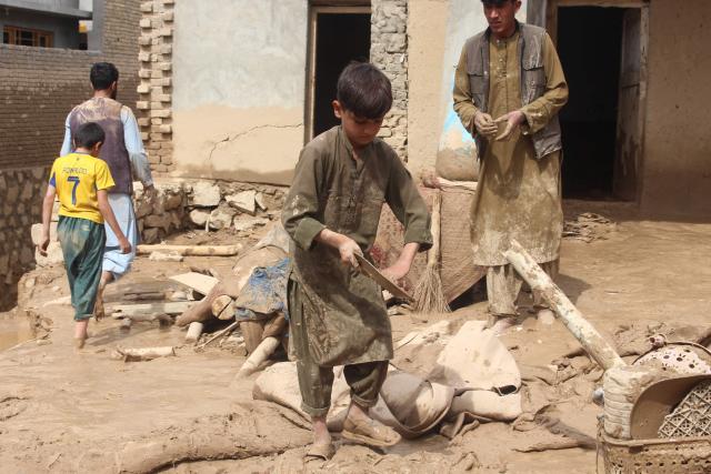 Afghan boys search for their household goods inside damaged homes after flash floods on the outskirts of Pul-e Khumri in Baghlan Province on April 1, 2026. Rain sweeping across Afghanistan has caused floods and landslides in multiple provinces. Among the poorest countries in the world after decades of war, Afghanistan is particularly exposed to the effects of climate change, which scientists say is spurring extreme weather. (Photo by AFP)