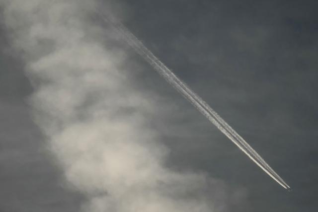 An aircraft leaves a vapour trail as it flies across the sky over Lucknow on April 1, 2026. (Photo by Sajjad HUSSAIN / AFP)