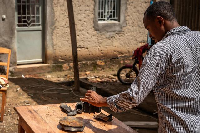 A resident inspects shrapnel from munitions that damaged a house following explosions after a fire at a military arsenal in the Musaga district of Bujumbura, on April 1, 2026. Explosions that ripped through the city of Bujumbura after a fire in a military arsenal have killed several dozen people in the Burundian economic capital, security sources told AFP on April 1, 2026.
The explosions erupted late on March 31, 2026 at the main ammunition depot of the Burundi National Defence Force (FDNB) in Musaga, a southern suburb of Bujumbura. (Photo by Fabrice Mbonankira / AFP)