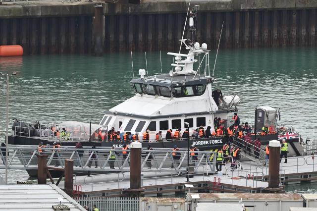 Migrants disembark a British Border Force vessel after being picked up at sea, while attempting to cross the English Channel from France, at the Port of Dover in southeast England, on April 01, 2026.  (Photo by JUSTIN TALLIS / AFP)
