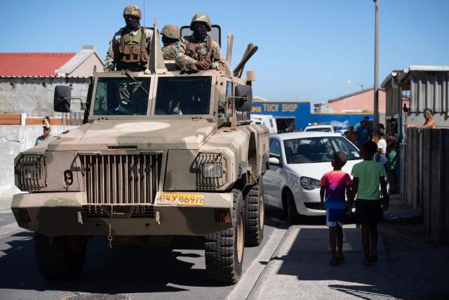 Soldiers of the South African National Defence Force (SANDF) ride in their Mamba armoured vehicle during a patrol as part of Operation Prosper in Mitchells Plain, near Cape Town, on April 1, 2026. Operation Prosper sees the SANDF play a supporting role to the South African Police Service (SAPS) in crime prevention operations. (Photo by RODGER BOSCH / AFP)
