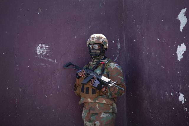 A soldier of the South African National Defence Force (SANDF) stands guard during a patrol as part of Operation Prosper in Mitchells Plain, near Cape Town, on April 1, 2026. Operation Prosper sees the SANDF play a supporting role to the South African Police Service (SAPS) in crime prevention operations. (Photo by RODGER BOSCH / AFP)