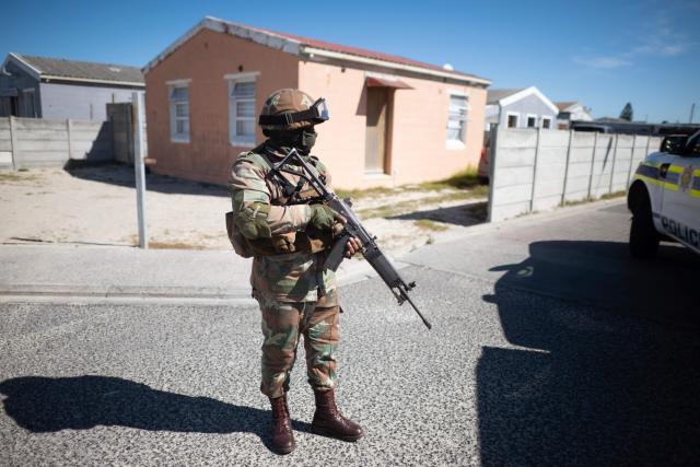 A soldier of the South African National Defence Force (SANDF) stands guard during a patrol as part of Operation Prosper in Mitchells Plain, near Cape Town, on April 1, 2026. Operation Prosper sees the SANDF play a supporting role to the South African Police Service (SAPS) in crime prevention operations. (Photo by RODGER BOSCH / AFP)