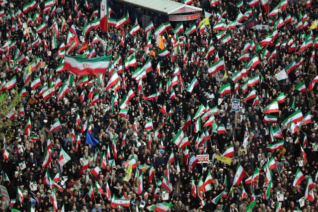 People wave Iranian flags while attending the funeral of Alireza Tangsiri, commander of the Iranian Revolutionary Guards' navy alongside others killed in US-Israeli strikes on Iran at Enghelab Square in Tehran on April 1, 2026. Iran confirmed on March 30 that an Israeli strike had killed the commander of the naval force of the Revolutionary Guards, who Israel had said was responsible for the blocking of the Strait of Hormuz. A statement carried by the Guards' Sepah News website said Alireza Tangsiri "succumbed to severe injuries" from the attack last week. (Photo by AFP) / 