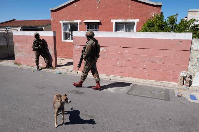 Soldiers of the South African National Defence Force (SANDF) patrols in a street as part of Operation Prosper in Mitchells Plain, near Cape Town, on April 1, 2026. Operation Prosper sees the SANDF play a supporting role to the South African Police Service (SAPS) in crime prevention operations. (Photo by RODGER BOSCH / AFP)