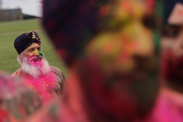 Soldiers from the Defence Sikh Network and British Army take part in Rang colour powder throwing during Holla Mohalla, the annual Sikh military festival, celebrating Sikh martial traditions at the Royal Military Academy at Sandhurst on April 01, 2026. Participants took part in a soldier Role fitness test, traditional Sikh martial arts, traditional Sikh military games, and Rang colour powder throwing. The centuries old festival is held in the spirit of fierce but well natured competition and aims to promote courage, preparation, and readiness. Sikhs have been serving in the British Army since the 1800s. (Photo by Adrian DENNIS / AFP)