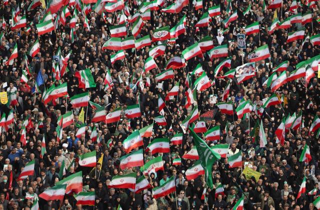 People wave Iranian flags while attending the funeral of Alireza Tangsiri, commander of the Iranian Revolutionary Guards' navy alongside others killed in US-Israeli strikes on Iran at Enghelab Square in Tehran on April 1, 2026. Iran confirmed on March 30 that an Israeli strike had killed the commander of the naval force of the Revolutionary Guards, who Israel had said was responsible for the blocking of the Strait of Hormuz. A statement carried by the Guards' Sepah News website said Alireza Tangsiri "succumbed to severe injuries" from the attack last week. (Photo by AFP) / 