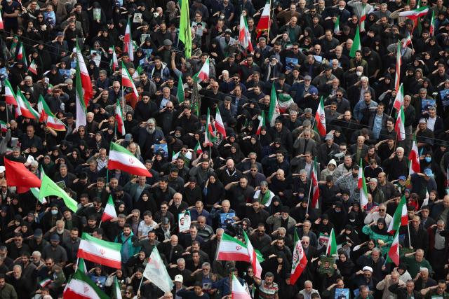 People salute during the funeral of Alireza Tangsiri, commander of the Iranian Revolutionary Guards' navy alongside others killed in US-Israeli strikes on Iran at Enghelab Square in Tehran on April 1, 2026. Iran confirmed on March 30 that an Israeli strike had killed the commander of the naval force of the Revolutionary Guards, who Israel had said was responsible for the blocking of the Strait of Hormuz. A statement carried by the Guards' Sepah News website said Alireza Tangsiri "succumbed to severe injuries" from the attack last week. (Photo by AFP) / 