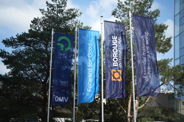 Company flags of Austrian energy group OMV, the Emirati firm ADNOC (Abu Dhabi National Oil Company) and Borouge International flutter in front of OMV’s headquarters in Vienna, on April 1, 2026. Austria’s hydrocarbons company OMV and the Emirati firm ADNOC (Abu Dhabi National Oil Company) jointly created a new global leader in plastics production, Borouge International, on March 31, 2026, confirming their diversification strategy in the fast-growing chemicals sector. (Photo by GEORG HOCHMUTH / APA / AFP) / Austria OUT