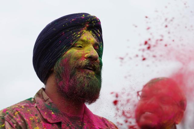 Soldiers from the Defence Sikh Network and British Army take part in Rang colour powder throwing during Holla Mohalla, the annual Sikh military festival, celebrating Sikh martial traditions at the Royal Military Academy at Sandhurst on April 01, 2026. Participants took part in a soldier Role fitness test, traditional Sikh martial arts, traditional Sikh military games, and Rang colour powder throwing. The centuries old festival is held in the spirit of fierce but well natured competition and aims to promote courage, preparation, and readiness. Sikhs have been serving in the British Army since the 1800s. (Photo by Adrian Dennis / AFP)