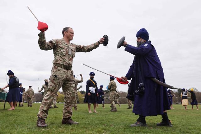 Jathedar Navjeet Singh of the Defence Sikh Network shows Commandant of Sandhurst Major General Nick Crowley of the British Army the science of the weapons as they take part Holla Mohalla, the annual Sikh military festival, celebrating Sikh martial traditions at the Royal Military Academy at Sandhurst on April 01, 2026. Participants took part in a soldier Role fitness test, traditional Sikh martial arts, traditional Sikh military games, and Rang colour powder throwing. The centuries old festival is held in the spirit of fierce but well natured competition and aims to promote courage, preparation, and readiness. Sikhs have been serving in the British Army since the 1800s. (Photo by Adrian DENNIS / AFP)