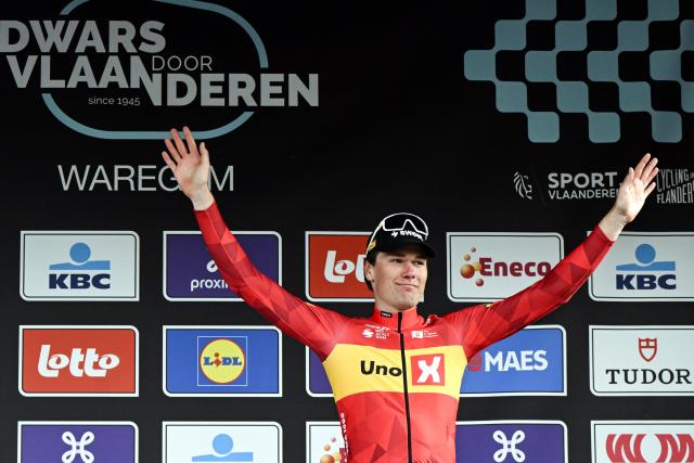 Bronze medallist Norwegian rider Soren Waerenskjold celebrates on the podium after competing in the men's elite race of the Dwars door Vlaanderen cycling event, 184.6km from Roeselare to Waregem on April 1, 2026. (Photo by Tom Goyvaerts / BELGA / AFP) / Belgium OUT