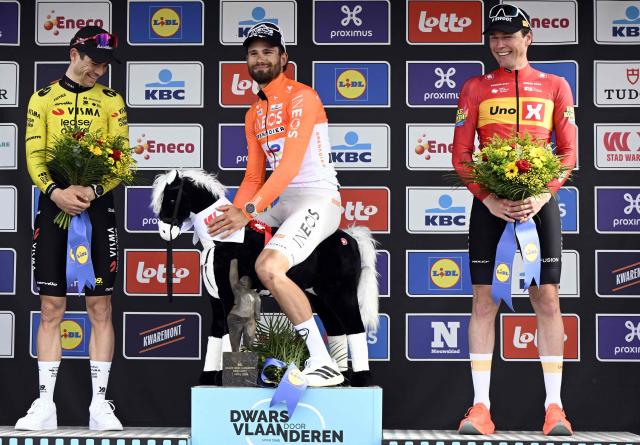 (From L) Silver medallist Team Visma-Lease a Bike's Belgian rider Wout van Aert, gold medallist INEOS Grenadiers' Italian rider Filippo Ganna and bronze medallist Norwegian rider Soren Waerenskjold celebrate on the podium after competing in the men's elite race of the Dwars door Vlaanderen cycling event, 184.6km from Roeselare to Waregem on April 1, 2026. (Photo by Tom Goyvaerts / BELGA / AFP) / Belgium OUT