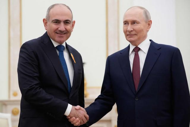 Russian President Vladimir Putin (R) greets Armenian Prime Minister Nikol Pashinyan prior to their meeting at the Kremlin in Moscow, on April 1, 2026. (Photo by Pavel Bednyakov / POOL / AFP)
