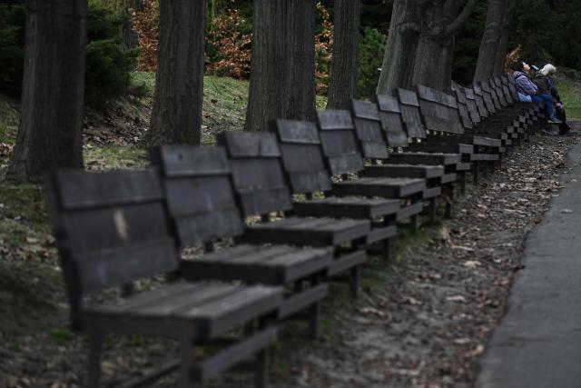 People walk relax at the Gryshko National Botanical Garden in Kyiv on April 1, 2026, amid the Russian invasion of Ukraine. (Photo by Genya SAVILOV / AFP)